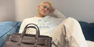 Mingyu tampil mengenakan pakaian serba putih, dari atasan long sleeveless putih dipadukan celana panjang putih. Member Seventeen ini membawa Dior Normandie Tote bag warna hitam. [@min9yu_k]