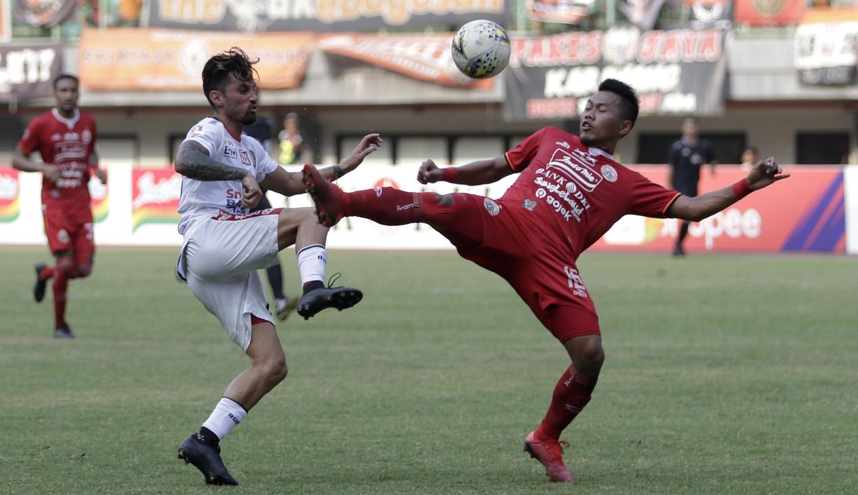 Penyerang Bali United, Stefano Lilipaly, berebut bola dengan bek Persija Jakarta, Tony Sucipto, pada laga Shopee Liga 1 di Stadion Patriot Chandrabhaga, Bekasi, Kamis (19/9). Bali United menang 1-0 atas Persija. (Bola.com/Yoppy Renato)