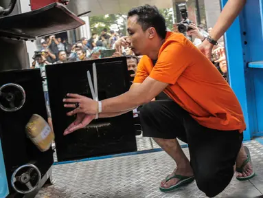 Tersangka memasukkan barang bukti narkoba ke dalam mesin insimilator saat pemusnahan di Bareskrim Mabes Polri, Jakarta, Selasa (9/7/2019). Bareskrim Polri memusnahkan 177,5 Kg sabu dan 30 ribu butir ekstasi yang disita dari jaringan Malaysia-Indonesia. (Liputan6.com/Fazail Fanani)