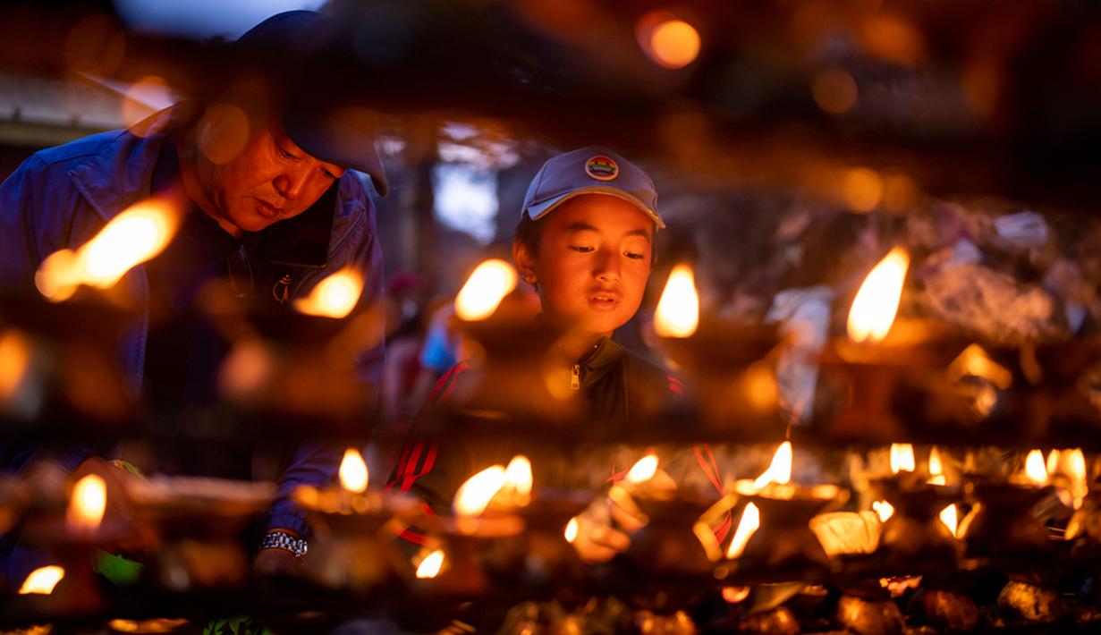 Seorang anak laki-laki menyalakan lampu minyak saat Festival Kuse Aunsi di Kuil Gokarneshwor, Kathmandu, Nepal, Kamis (14/9/2023). Kuse Aunsi adalah festival di mana para ayah, baik yang masih hidup maupun yang sudah meninggal, dihormati. (AP Photo/Niranjan Shrestha)