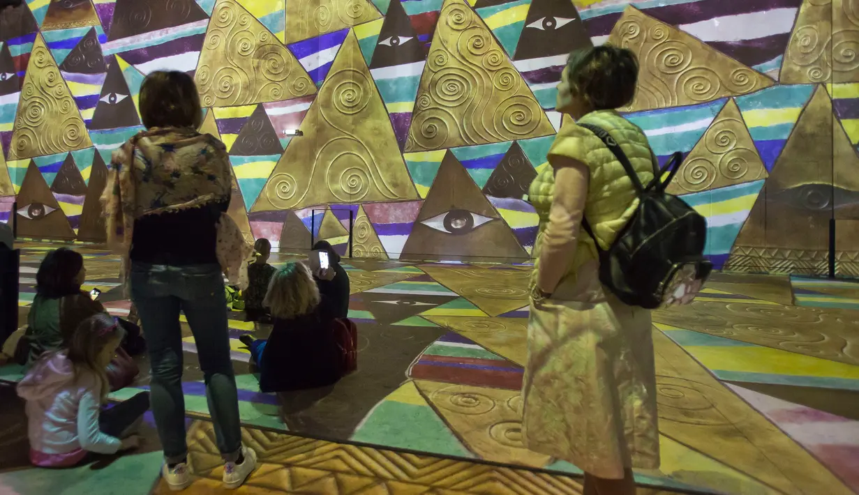 Pengunjung melihat karya dari pelukis Austria, Gustav Klimt dalam pameran seni proyeksi di galeri l'Atelier des Lumieres di Paris, Prancis (24/4). Dalam pameran ini pengunjung bisa menikmati lukisan dalam bentuk digital. (AP/Michel Euler)