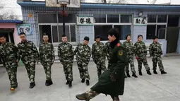 Seorang mantan anggota militer Tiongkok mengajarkan baris berbaris di Pusat Pendidikan Qide, Beijing, 19/2/2014. Pusat Pendidikan Qide merupakan sebuah camp bergaya militer yang menawarkan pengobatan untuk para pecandu internet. (REUTERS/Kim Kyung-Hoon)