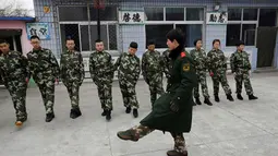 Seorang mantan anggota militer Tiongkok mengajarkan baris berbaris di Pusat Pendidikan Qide, Beijing, 19/2/2014. Pusat Pendidikan Qide merupakan sebuah camp bergaya militer yang menawarkan pengobatan untuk para pecandu internet. (REUTERS/Kim Kyung-Hoon)