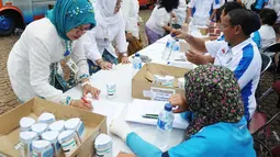 Sejumlah Pegawai Negeri Sipil di lingkungan Pemprov DKI Jakarta menjalani tes urine di kawasan Monumen Nasional (Monas), Jakarta, Jumat (2/1/2015). Tampak sejumlah PNS melakukan pendataan jelang menjalani tes urine. (Liputan6.com/Faizal Fanani)