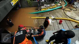 Petugas Damkar PB menyalakan mesin penyedot air saat melakukan pengeringan di salah satu pertokoan di Jalan Kemang Raya, Jakarta, Minggu (28/8). Dua lokasi parkir bawah tanah pertokoan di kawasan Kemang terendam air. (Liputan6.com/Helmi Fithriansyah)
