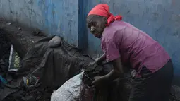Seorang wanita mengumpulkan arang di depot yang akan dijualnya di pasar lokal, di Les Cayes, Haiti, (25/1). Peraturan tersebut untuk melindungi zona pemotongan kayu. (AP/David McFadden)