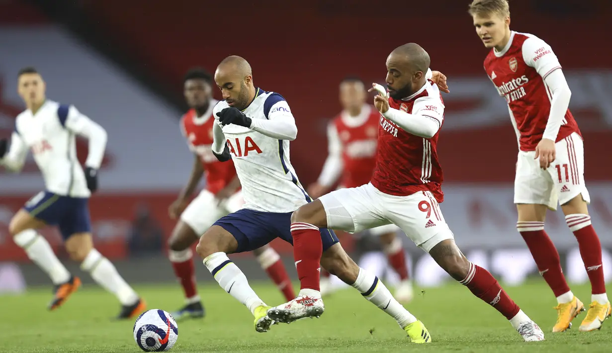 Gelandang Tottenham Hotspur, Lucas Moura bersaing dengan penyerang Arsenal, Alexandre Lacazette dalam derby London Utara Liga Inggris di Emirates Stadium, Minggu (14/3/2021). Sempat tertinggal lebih dulu, Arsenal menang 2-1 di kandang sendiri melawan Tottenham Hotspur. (Julian Finney/Pool via AP)
