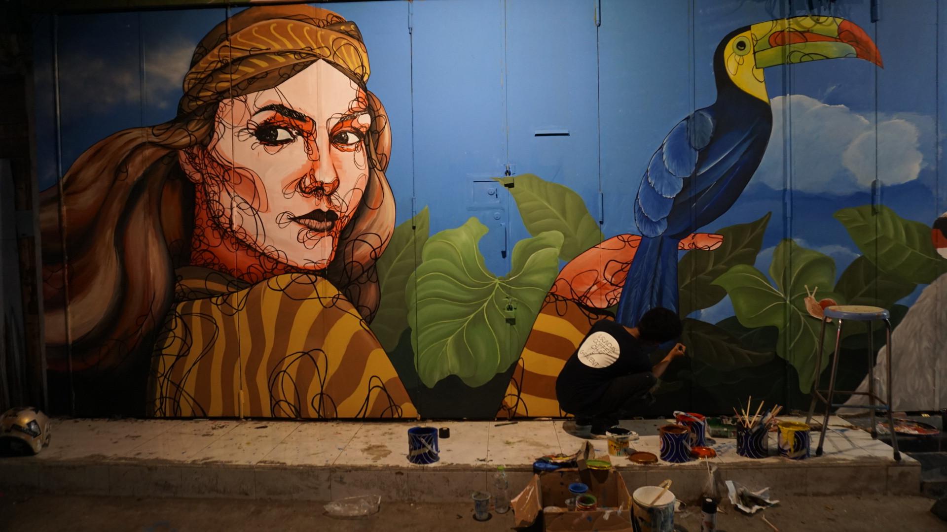 Sejumlah anak muda di Solo sedang menyelesaikan lukisan mural di tembok maupun pintu pertokoan yang terletak di Jalan Gatot Subroto, Solo.(Liputan6/Fajar Abrori)