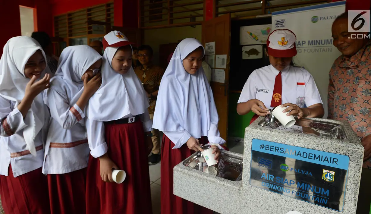 Para siswa antre mengambil air bersih langsung dari keran di SDN 03 dan SDN 04 Penjaringan, Jakarta, Jumat (22/3). Kegiatan ini bertujuan menyediakan air siap minum yang higenis dan bersih bagi siswa serta guru. (merdeka.com/Imam Buhori)