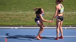 Pelari Nikki Hamblin terlihat membantu pelari AS, Abbey D'Agostino saat mengalami nyeri kaki setelah terjatuh pada lari 5000m putri Olimpiade Rio 2016 di Olympic  Stadium, Rio de Janeiro, (16/8/2016). (AFP/Johannes Eisele)