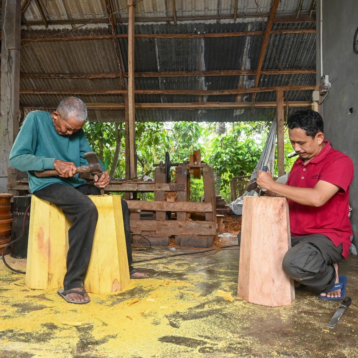 Utoh Amad (baju hijau) bersama Muzayin Nazaruddin (baju Merah: Peneliti) tengah melubangi potongan kayu yang akan dijadikan sebagai Alee Tunjang