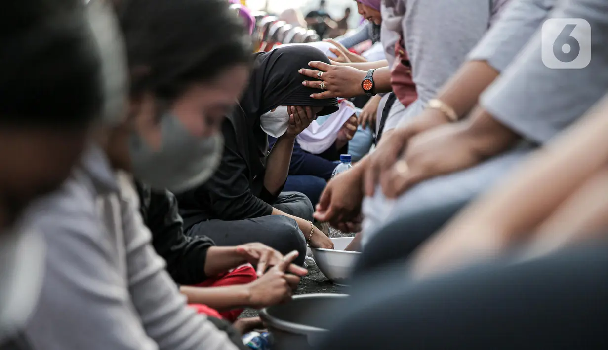 Sejumlah anak mencuci kaki ibunya pada aksi cuci kaki ibu massal di Jakarta, Minggu (18/12/2022). Aksi yang diikuti sebanyak ratusann peserta itu bertujuan untuk meningkatkan rasa cinta kasih kepada ibu , khususnya dalam rangka memperingati Hari Ibu. (Liputan6.com/Faizal Fanani)