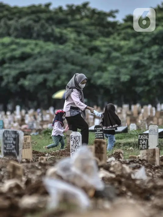 Warga berziarah ke makam anggota keluarga yang dikebumikan dengan protokol Covid-19 di TPU Tegal Alur, Jakarta, Kamis (14/1/2021). Kepala Satuan Pelaksana TPU Tegal Alur Wawan Wahyudi mengungkapkan blok pemakaman muslim khusus jenazah terpapar Covid-19 telah penuh. (merdeka.com/Iqbal S. Nugroho)