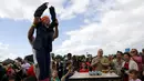 Anya Dawson (8 tahun), mengangkat kedua tangannya usai memenangkan permainan Russian Egg Roulette dalam acara Kompetisi Melempar Telur Dunia dan Vintage Day di Swaton, Inggris, Minggu (28/6/2015). (REUTERS/Darren Staples)