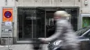 Seorang pengendara sepeda melewati toko yang tutup di Munich, Jerman, Selasa (23/3/2021). Jerman memperpanjang tindakan pengunciannya sebulan lagi. (AP Photo/Matthias Schrader)