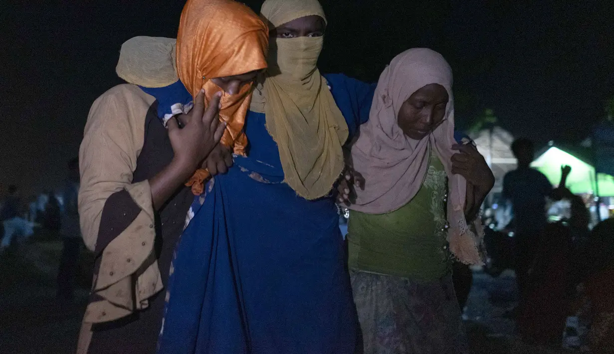 Seorang wanita etnis Rohingya dibantu berjalan oleh orang lain setelah perahu yang membawa mereka mendarat di Lhokseumawe, provinsi Aceh, Senin (7/9/2020). (AP Photo/Zik Maulana)