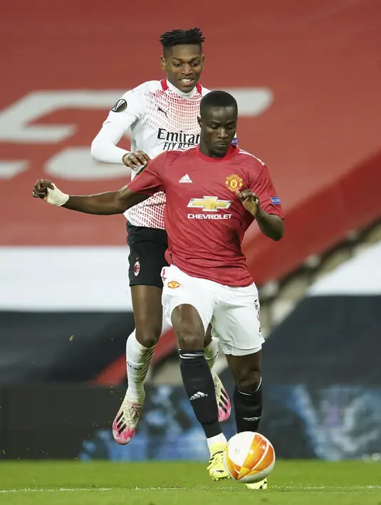 Penyerang AC Milan, Rafael Leao berusaha merebut bola dari bek Manchester United, Eric Bailly pada pertandingan leg pertama babak 16 besar Liga Europa di Old Trafford, Inggris, Jumat (12/3/2021). Pertandingan berjalan seimbang di babak pertama dengan skor 0-0. (AP Photo/Dave Thompson)