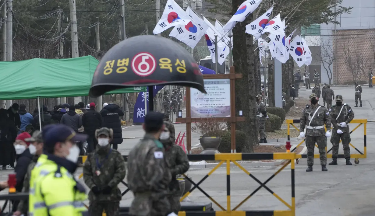 Tentara Korea Selatan berjaga-jaga setelah personel boy group BTS, Jin tiba di pusat pelatihan militer di Yeoncheon, Korea Selatan, Selasa (13/12/2022). Saat tiba di pusat pelatihan, para penggemar berkumpul mengucapkan selamat tinggal kepada personel tertua BTS tersebut. (AP Photo/Ahn Young-joon)