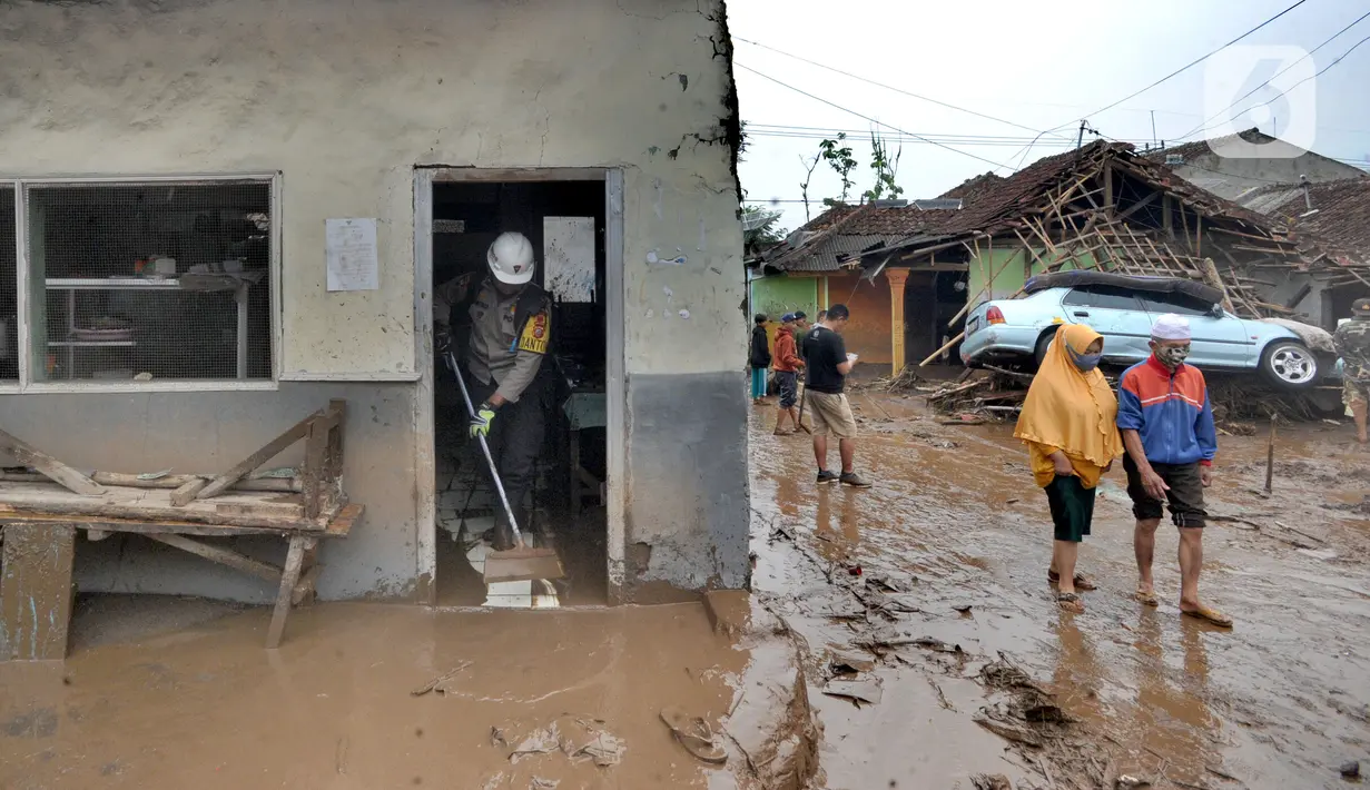 Anggota polisi membersihkan material longsor usai banjir bandang menerjang Kampung Cibuntu, Desa Pasawahan, Kecamatan Cicurug, Sukabumi, Selasa (22/9/2020). Banjir mengakibatkan puluhan bangunan rusak berat, 12 rumah hanyut, dan dua korban hilang. (merdeka.com/Arie Basuki)