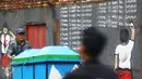 Seorang pedagang kerupuk mengendarai gerobaknya melintas di depan mural anti korupsi bertuliskan 'I promise i'll learn not corruption' atau 'Saya berjanji saya akan belajar untuk tidak korupsi' di Jakarta, Minggu (05/03). (Liputan6.com/Helmi Afandi)