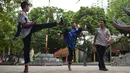 Pemuda Vietnam memainkan permainan "da cau" atau bulutangkis menggunakan bagian tubuh di dalam kompleks kuil Budha di Hanoi pada 25 Oktober 2019. Da Cau mirip dengan bulutangkis, tetapi tidak menggunakan raket untuk memukul kok, melainkan menggunakan setiap bagian tubuh.  (Nhac NGUYEN / AFP)