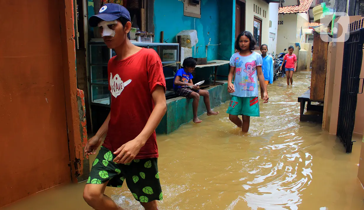 Aktivitas sejumlah anak saat banjir di kawasan Bidara Cina, Kecamatan Jatinegara, Jakarta Timur, Selasa (25/2/2020). Baru satu hari air surut, kawasan Bidara Cina yang bersebelahan dengan Kali Ciliwung kembali mengalami banjir. (merdeka.com/magang/ Muhammad Fayyadh)