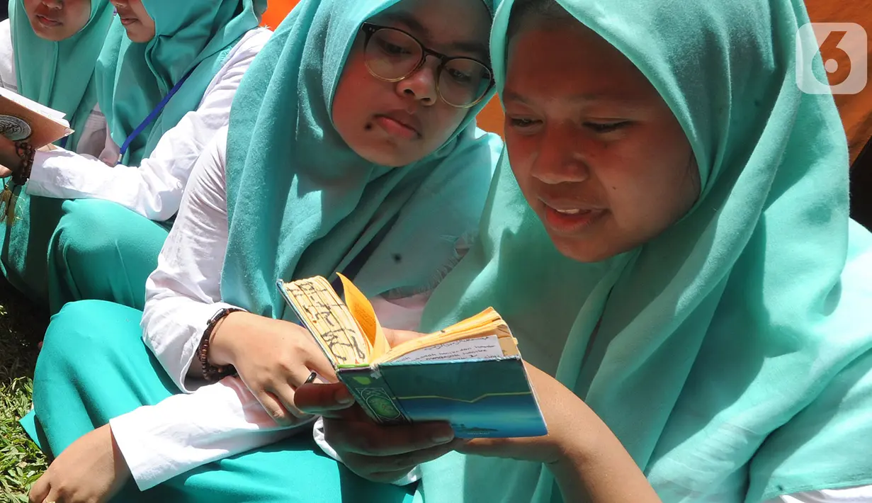 Santri membaca Al-Qur'an saat kegiatan Kemah Hari  Santri di Bogor, Selasa (22/10/2019). Pemerintah menetapkan 22 Oktober sebagai HSN bertepatan dengan Resolusi Jihad yang dikumandangkan  pendiri Nahdlatul Ulama KH. Hasyim Asyari untuk mempertahankan kemerdekaan RI. (merdeka.com/Arie Basuki)
