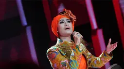 Iis Dahlia yang mengenakan gaun berwarna orange tampil memukau menghibur penonton di Malam Puncak Putri Muslimah Indonesia 2014, TMII, Jakarta, Rabu (28/5/2014) (Liputan 6.com/Andrian M Tunay)