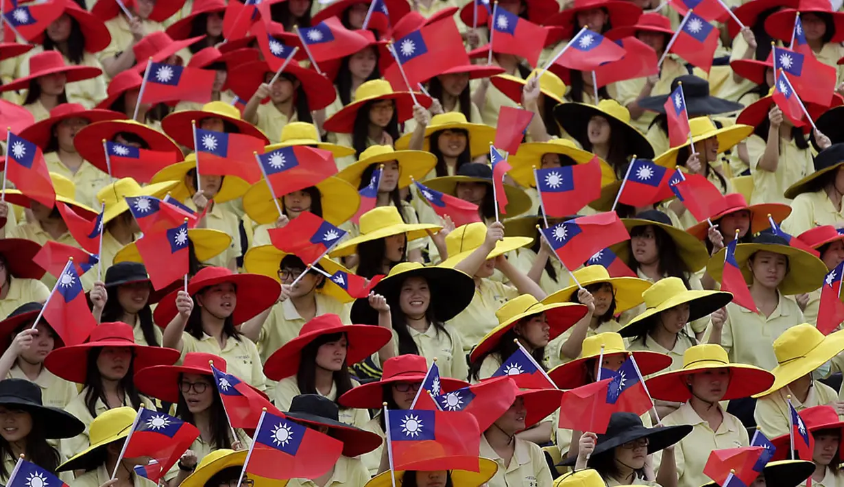 Sejumlah peserta melambaikan bendera saat perayaan Hari Nasional Taiwan di depan Kantor Kepresidenan di Taipei, (10/10/2014). (REUTERS/Pichi Chuang)