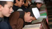 Ekspresi anak-anak saat belajar membaca Alquran di sebuah masjid di Kabul, Afghanistan, Senin, (21/5). Anak-anak Afghanistan lebih memperdalam Alquran di saat Ramadan. (AP Photo/Rahmat Gul)