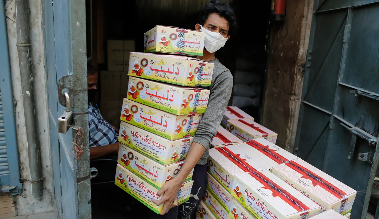 Seorang pekerja India membawa paket bihun di sebuah pabrik di Prayagraj, India pada 25 April 2020. Bihun diminati di kalangan Muslim ketika mereka berbuka puasa selama bulan suci Ramadan. (AP Photo/Rajesh Kumar Singh)