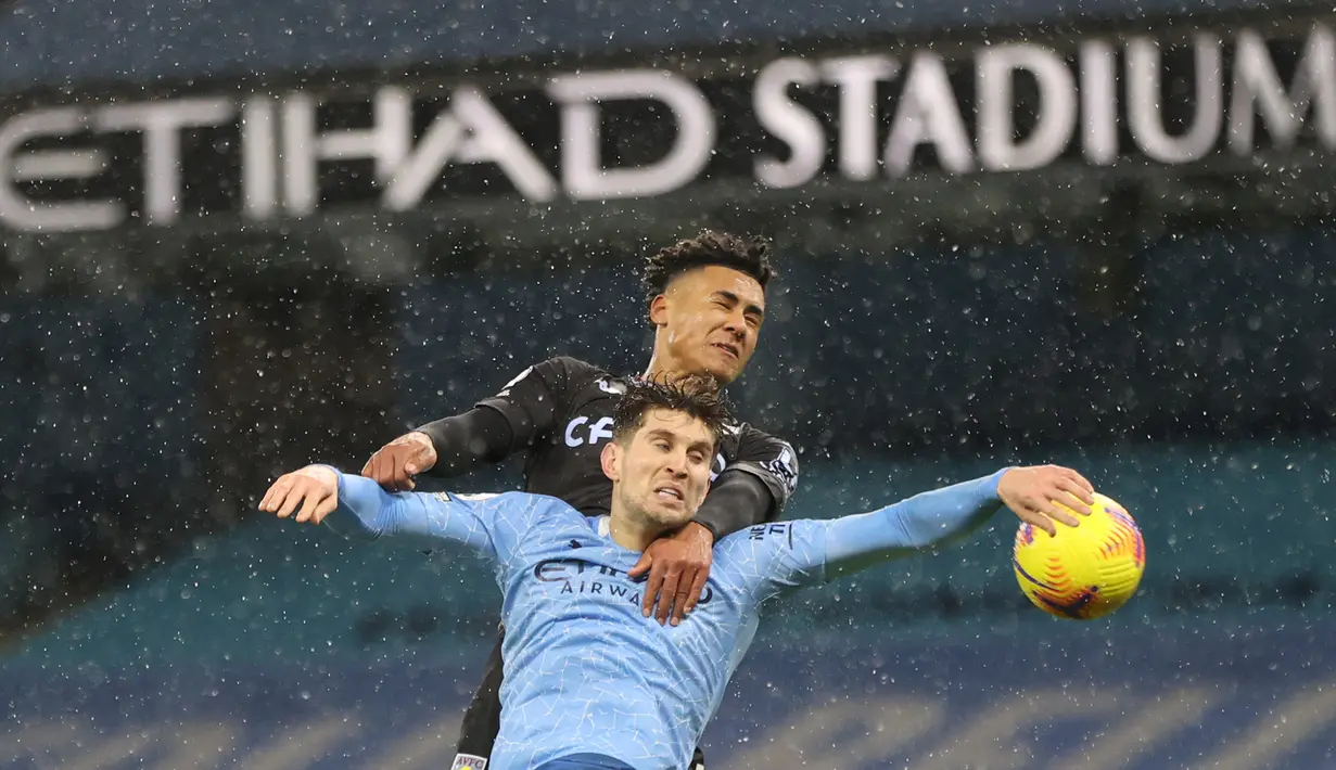 Bek Manchester City, John Stones, berebut bola dengan striker Aston Villa, Ollie Watkins, pada laga lanjutan Liga Inggris di Etihad Stadium, Kamis (21/1/2021) dini hari WIB. Manchester City menang 2-0 atas Aston Villa. (AFP/Clive Brunskill/pool)