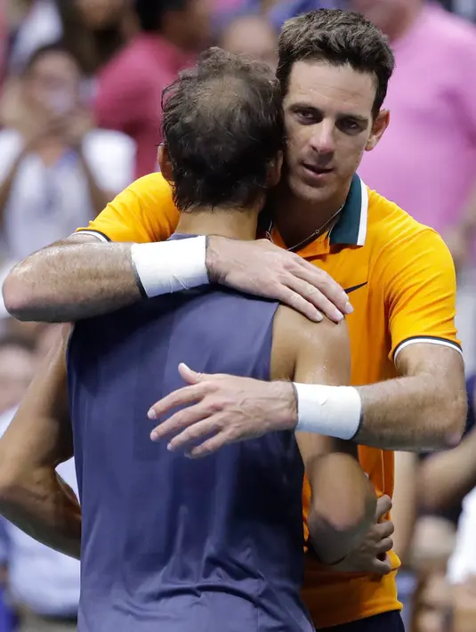 Petenis Argentina, Juan Martin del Potro memeluk Rafael Nadal dari Spanyol yang mengundurkan diri pada laga semifinal AS Terbuka 2018, Jumat (7/9). Itu berarti, Del Potro melangkah ke final AS Terbuka untuk pertama kalinya setelah 2009. (AP/Seth Wenig)