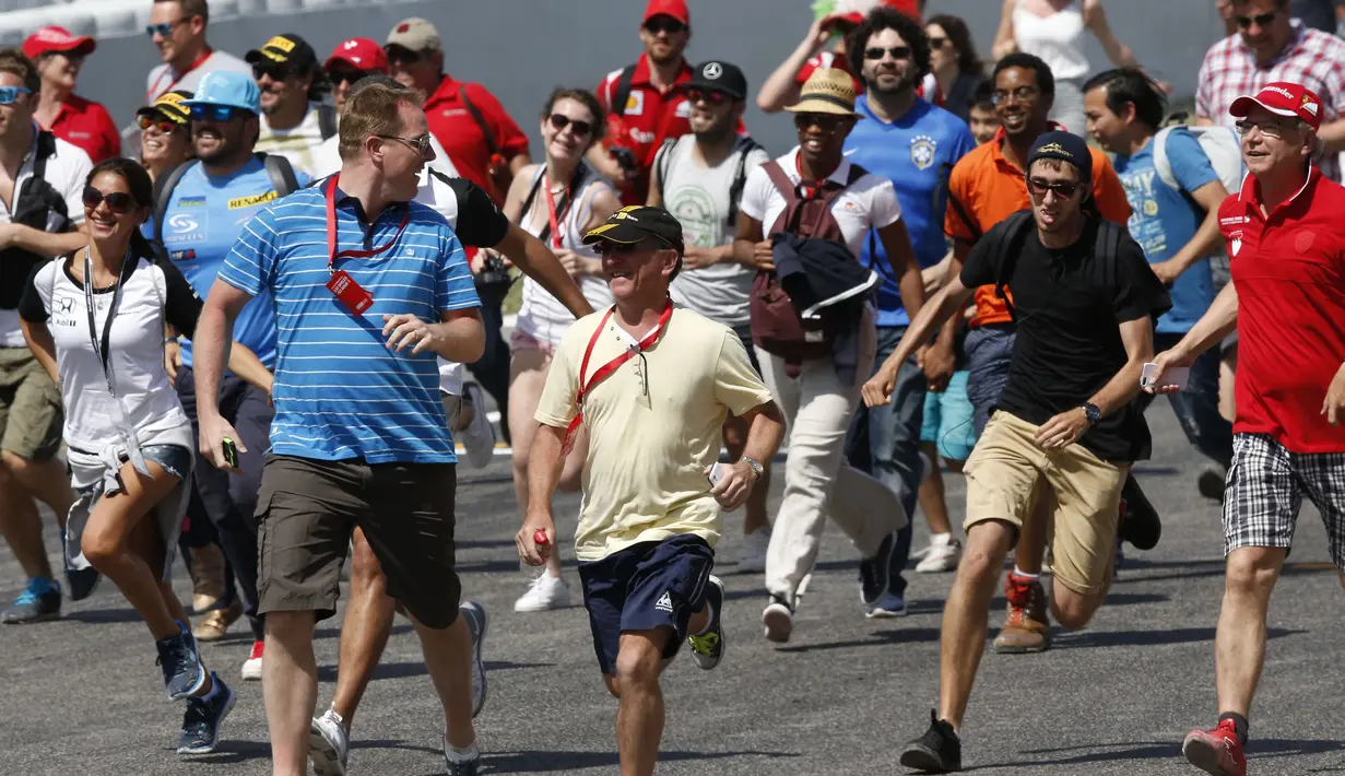 Para fan berlari mendekati area podium. (Reuters/Gustau Nacarino) 