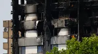Kondisi bangunan apartemen Grenfell Tower di London usai kebakaran dahsyat, Minggu (18/6). Perkembangan terakhir menyebutkan 30 orang tewas dan lebih dari 70 residen masih hilang dalam insiden kebakaran apartemen 24 lantai itu. (TOLGA AKMEN/AFP)