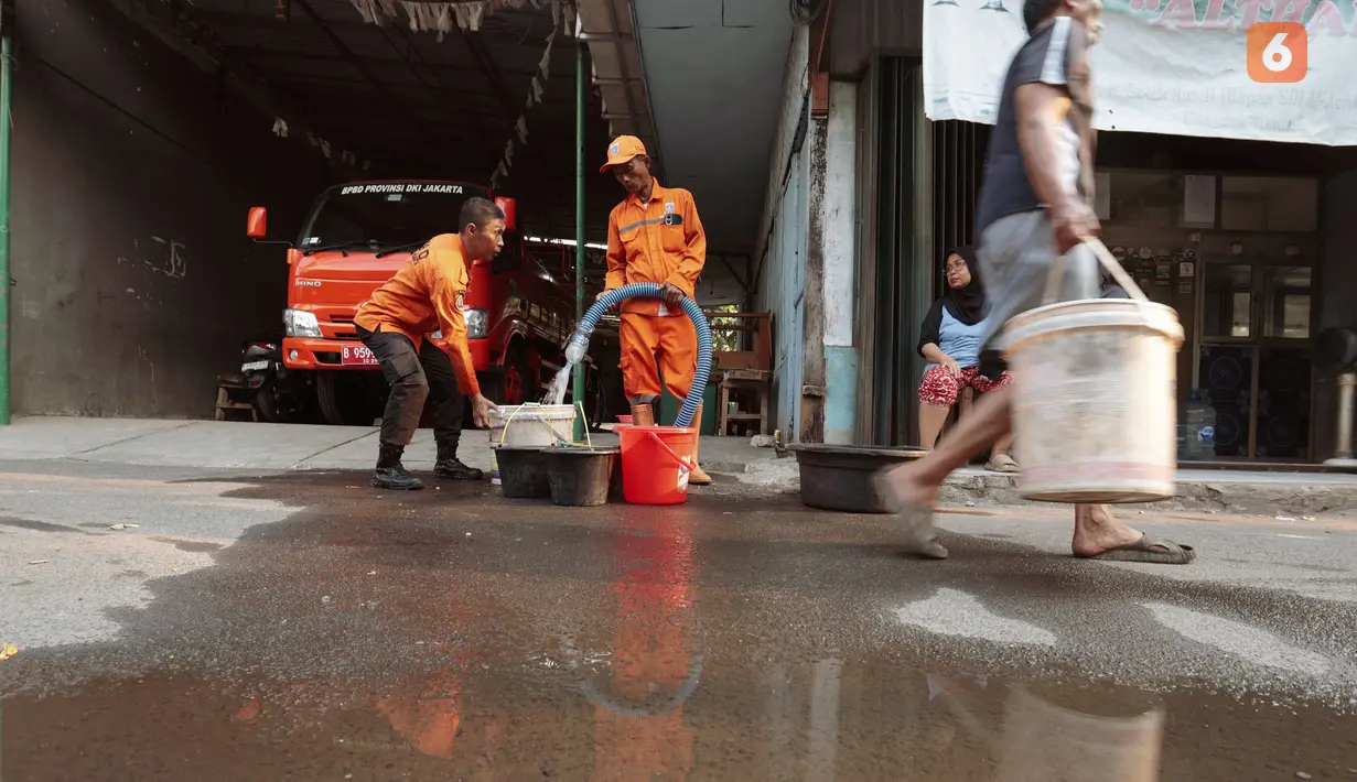 Petugas BPBD DKI Jakarta menyalurkan air bersih kepada warga di Gang H Soleh, Cilandak Timur, Jakarta Selatan, Senin (21/9/2026). Bantuan diberikan menyusul kekeringan yang melanda sejumlah wilayah di Cilandak Timur. (KLY/Budy Santoso)