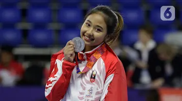 Pesenam Indonesia, Rifda Irfanaluthfi, berpose dengan medali perak usai pertandingan Senam Artistik SEA Games 2019 di Kompleks Rizal Memorial, Manila, Senin (2/12/2019). Rifda Irfanaluthfi berhasil meraih medali dari nomor all-round individual putri cabang senam. (Bola.com/M Iqbal Ichsan)