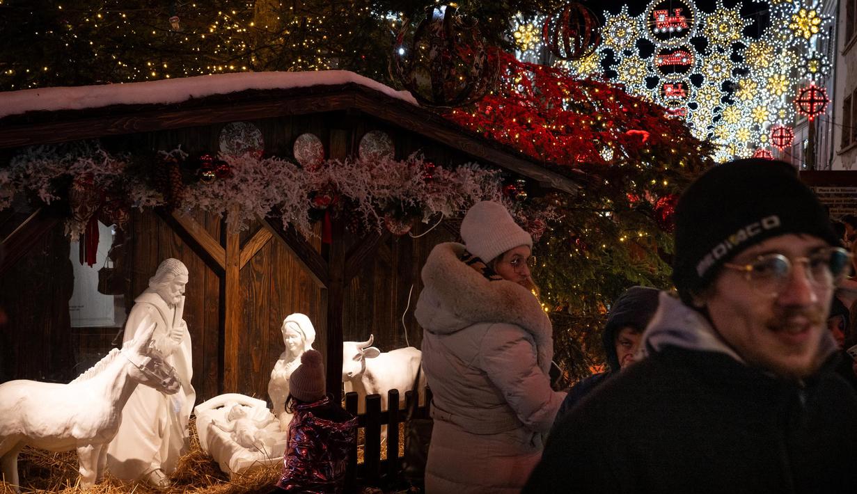Orang-orang berjalan di pasar Natal Mulhouse, Prancis timur, pada 23 November 2024. (SEBASTIEN BOZON/AFP)