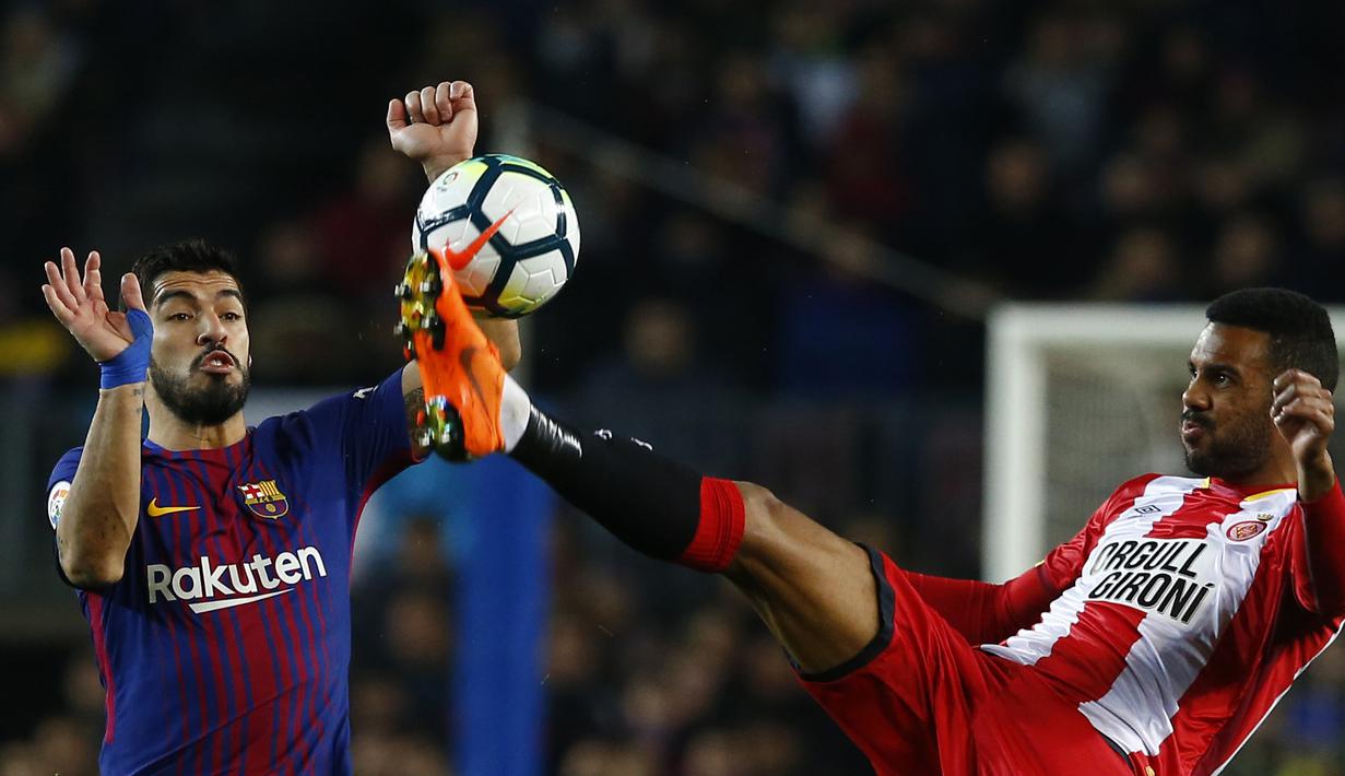 Duel pemain Barcelona, Luis Suarez (kiri) dan pemain Girona, Jonas Ramalho pada La Liga Santander di Camp Nou stadium, Barcelona, (24/2/2018). Barcelona menang telak 6-1. (AP/Manu Fernandez)