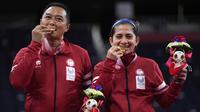Hary Susanto dan Leani Ratri Oktila (Indonesia) berfoto setelah menerima medali emas pada pertandingan ganda campuran cabang badminton nomor SL3-SU5 Paralimpiade Tokyo 2020, Minggu (5/9/2021). Hary/Leani menang atas pasangan Prancis Lucas Mazur/Faustine Noel, 23-21 dan 21-17. (AP/Kiichiro Sato)