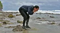 Sesampainya di bibir pantai, Jokowi jongkok mencuci tangan lalu membasuh mukanya dengan air laut, Sulawesi Utara (19/10). Dalam kunjungan kerjanya, Jokowi meresmikan beroperasinya Bandar Udara Miangas. (Agus Suparto)