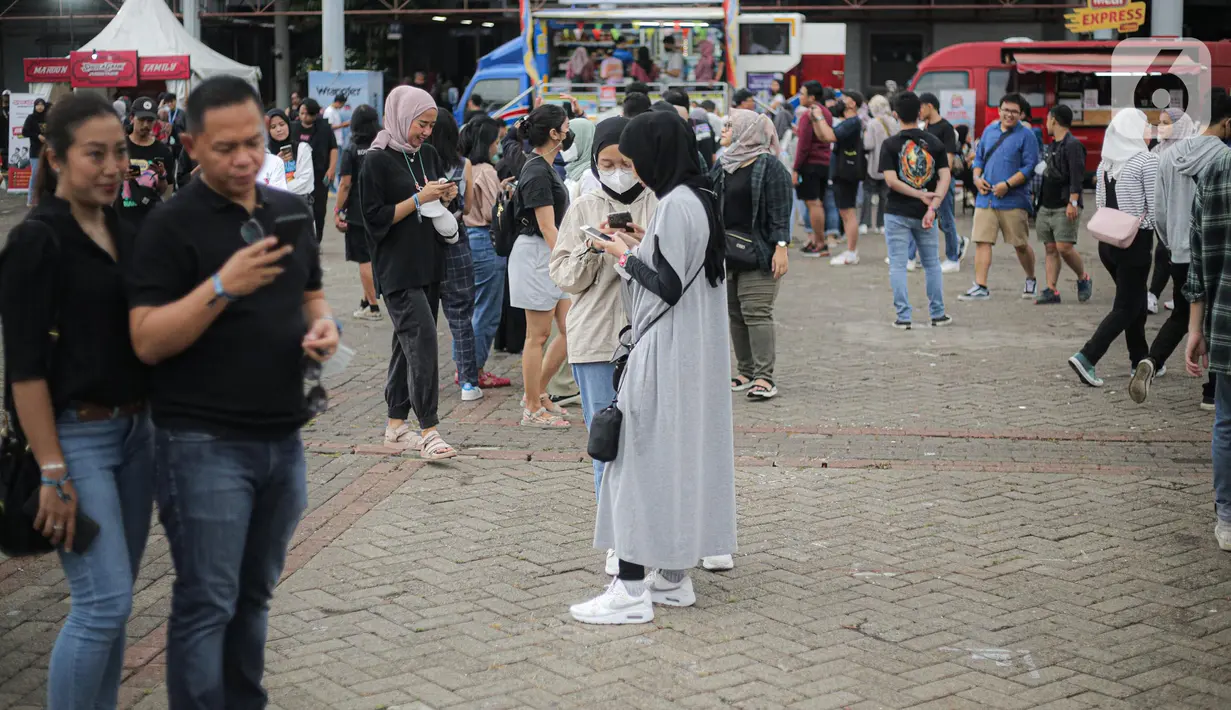 Penonton tiba untuk menyaksikan konser Sheila On 7 yang bertajuk 'Tunggu Aku di Jakarta' di kawasan JIExpo Kemayoran, Jakarta Pusat, Sabtu, (28/1/2023). Jelang penampilan grup musik Sheila On 7 dalam konser bertajuk 'Tunggu Aku di Jakarta' penonton mulai memadati kawasan tersebut. (Liputan6.com/Faizal Fanani)
