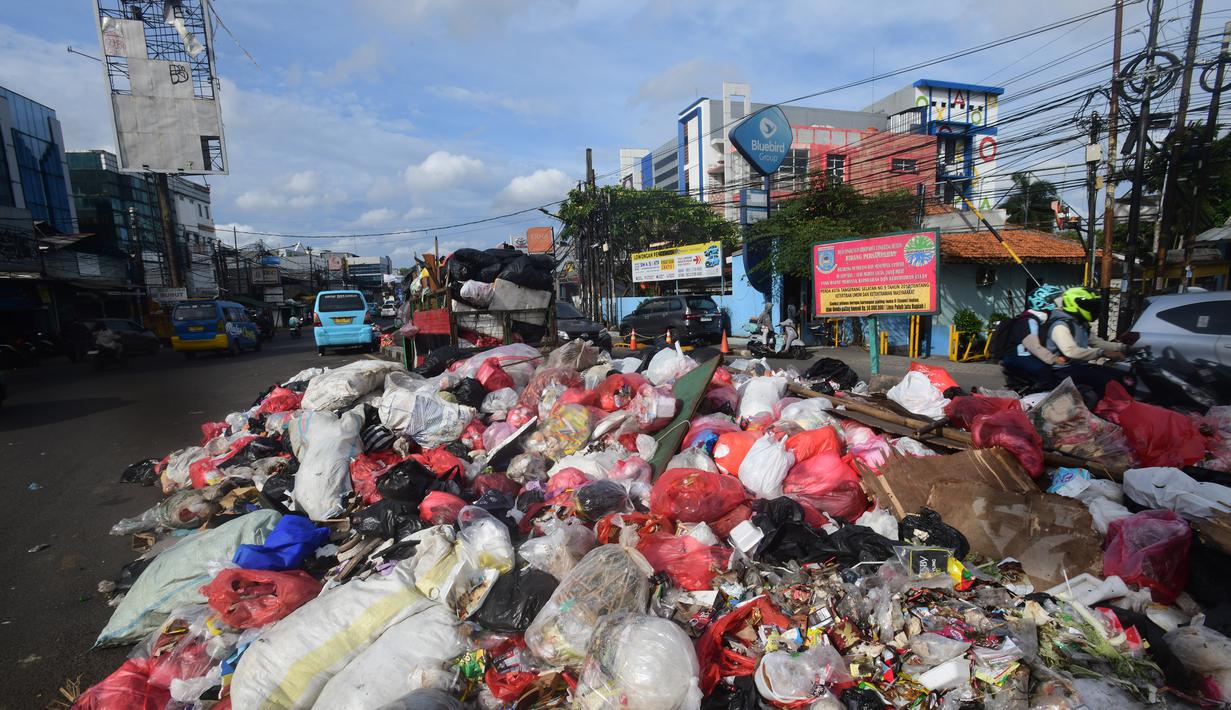 Diketahui, tumpukan sampah tersebut belum terangkut karena kondisi Tempat Pembuangan Akhir (TPA) Cipeucang, Serpong, Kota Tangerang Selatan saat ini sedang dilakukan penutupan sementara. Tampak dalam foto, pengendara melintas di dekat tumpukan sampah diletakkan pada salah sisi satu ruas jalan di kawasan Pasar Manggis, Ciputat, Tangerang Selatan, Senin (15/12/2025). (merdeka.com/Arie Basuki)