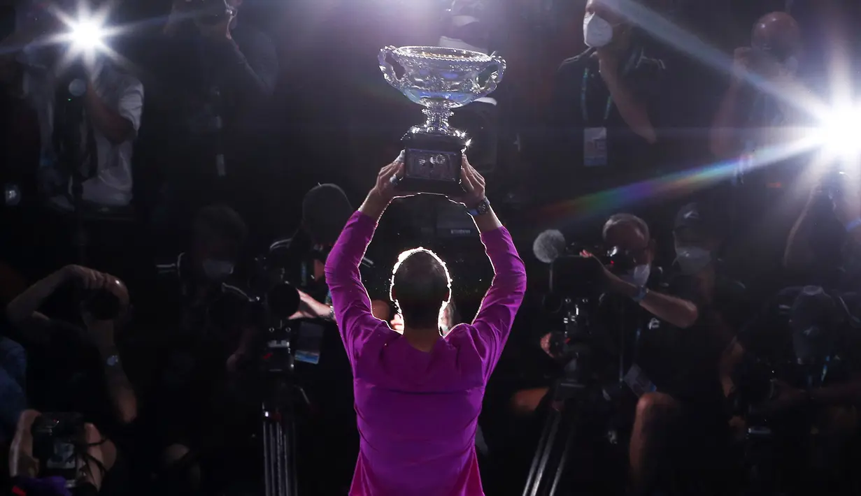 Petenis asal Spanyol, Rafael Nadal sukses mengunci gelar ke-21 grand slamnya usai mengalahkan petenis nomor dua dunia, Daniil Medvedev di laga final Australia Open 2022, Minggu (30/01/2022). (AFP/Brandon Malone)