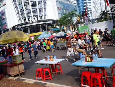 Pedagang kaki lima (PKL) berjualan ketika pelaksanaan Car Free Day di kawasan Senayan, Jakarta, Minggu (8/10). Kurangnya pengawasan petugas membuat Kawasan CFD yang sebelumnya bebas PKL, kini mulai marak kembali. (Liputan6.com/Fery Pradolo)