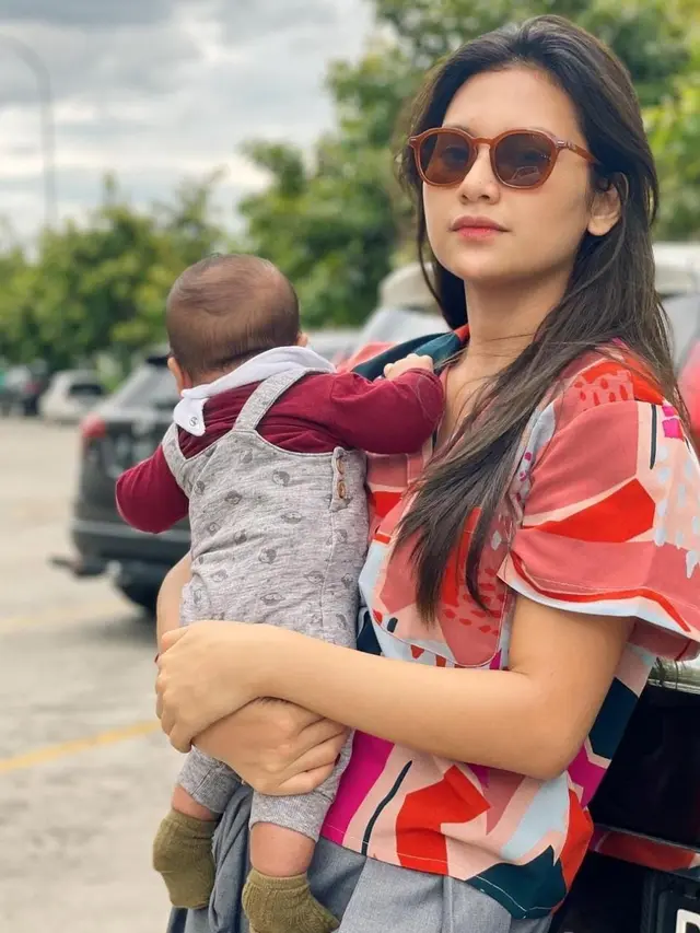 Indah Permatasari dan Arie Kriting sengaja menutupi wajah sang anak