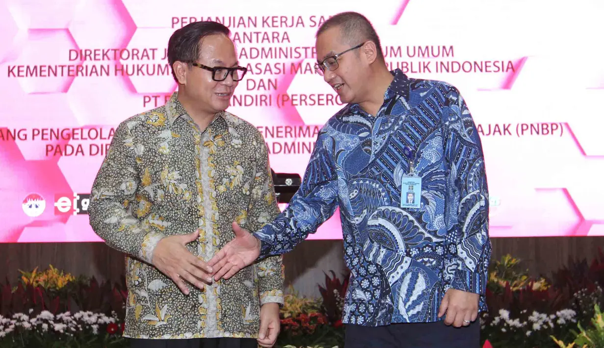 Dirut Bank Mandiri Kartika Wirjoatmodjo dan Dirjen AHU Kemenkumham Cahyo Rahadian Muzhar bersalaman usai penandatanganan perjanjian kerja sama di Jakarta, Kamis (1/8/2019). Bank Mandiri menyediakan fasilitas layanan pembayaran PNBP secara online/realtime. (Liputan6.com/Angga Yuniar)