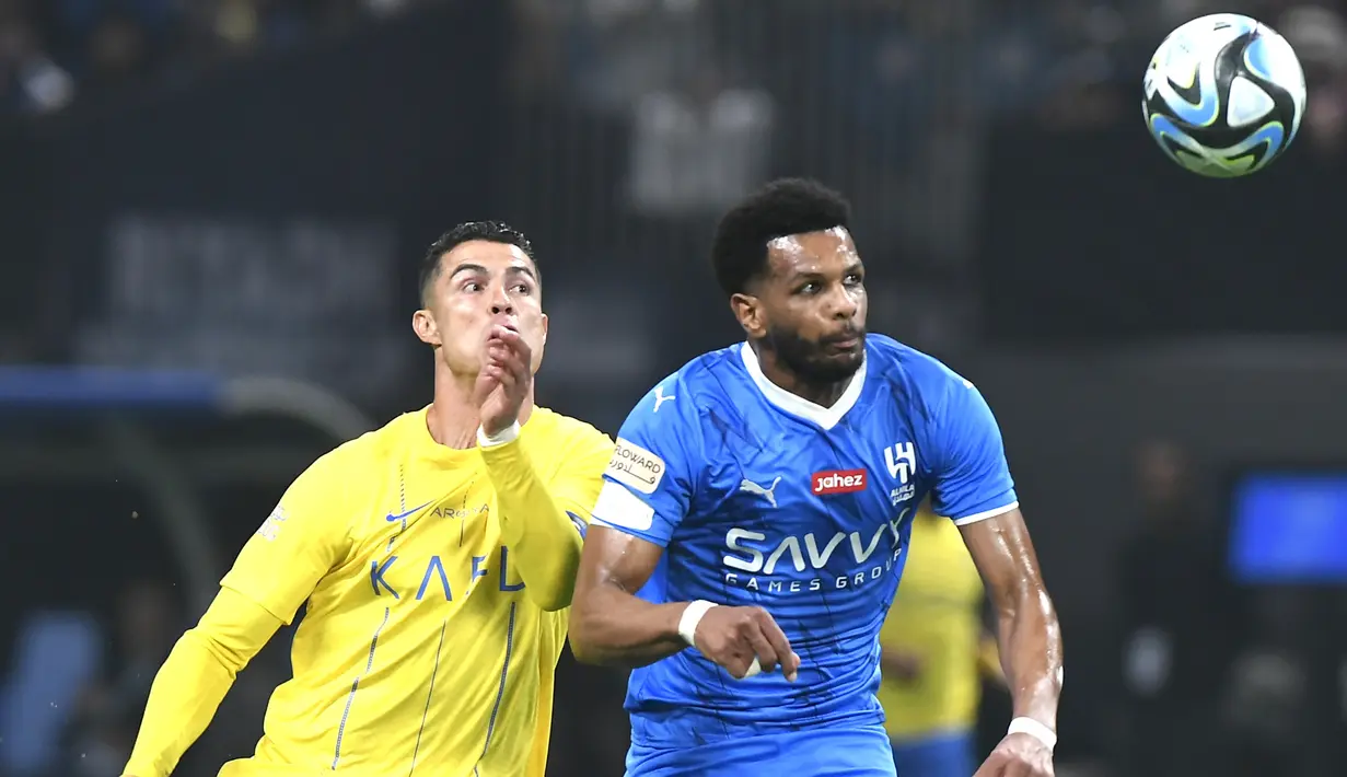 Pemain Al-Nassr, Cristiano Ronaldo, duel udara dengan pemain Al-Hilal, Al Bulayhi, pada laga persahabatan di Kingdom Arena, Riyadh, Jumat (9/2/2024). (AP Photo)