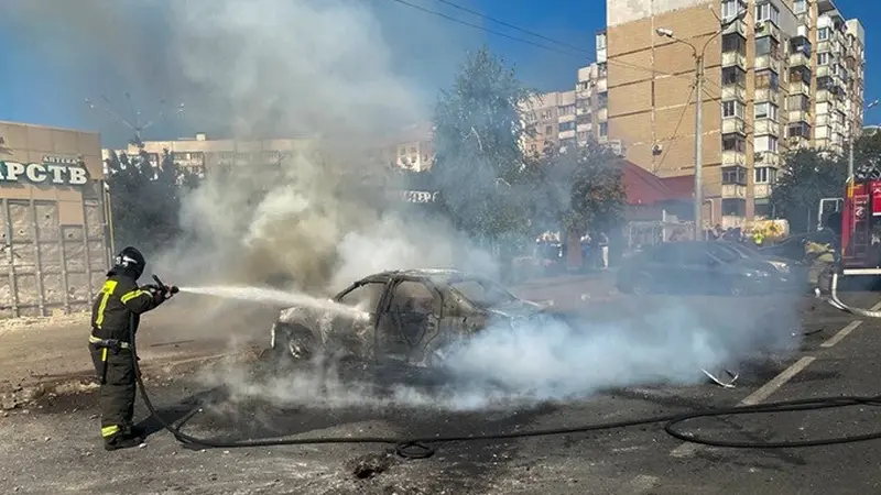 Petugas pemadam kebakaran memadamkan mobil yang terbakar di halaman gedung apartemen setelah serangan rudal oleh Angkatan Bersenjata Ukraina di Kota Belgorod, Rusia.