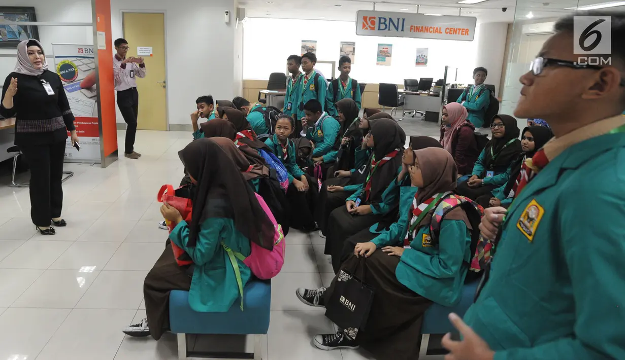 Karyawan BNI memberi pengetahuan tentang perbankan kepada para siswa saat berkunjung ke BNI Kantor Cabang Tebet, Jakarta (2/5). (Merdeka.com/Arie Basuki)